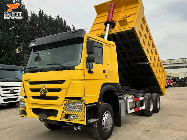 Raised yellow HOWO 371 6x4 cargo body with the hydraulic cylinder visible